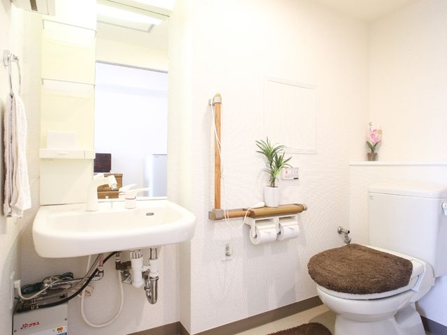 清潔なトイレ空間 トイレ きれいに整えられたトイレの横には、手洗いをするための洗面台が設置されています。快適な使用感を保つために、日々の清掃が行き届いています。