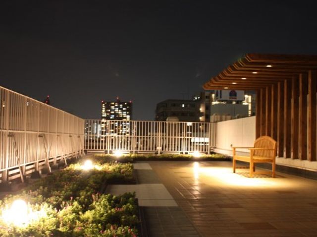 夜の屋上庭園風景 屋上庭園 夜に照らされた安らぎの屋上が、心身のリフレッシュに最適な環境を提供しています。ベンチで静かなひと時をお過ごしいただけます。