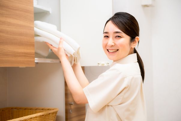 笑顔のスタッフがリネン整理中
