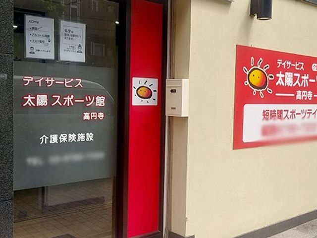 明るい入口の看板 看板   太陽のイラストが特徴の看板があるエントランスです。施設の名前が明記されています。