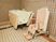 サムネイル 広い浴室に、車椅子タイプの入浴装置が置かれている。ピンク色と白で統一された空間で、居心地の良い入浴スペースになっている。