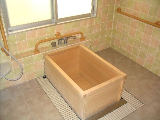 手すり付き浴室の木製浴槽