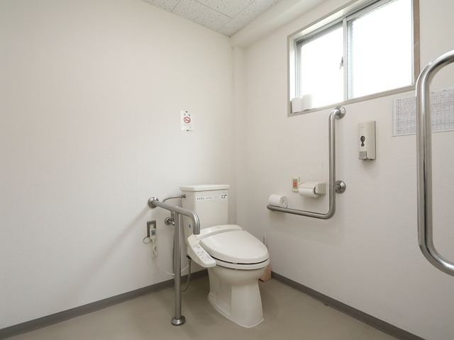 バリアフリートイレ トイレ 手すり付きで広々としたトイレ空間です。どなたでも安全にご利用いただける配慮がされています。
