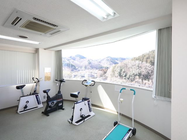 トレーニング機器のある部屋 機能訓練室 山並みを望む明るい部屋には、健康維持のためのトレーニング機器が整っており、日々のリハビリが快適に行えます。