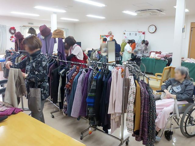賑わいのある屋内交流スペース 多目的室 広々とした交流スペースでは、住人たちが様々な服を見ながらリラックスした時間を過ごしています。