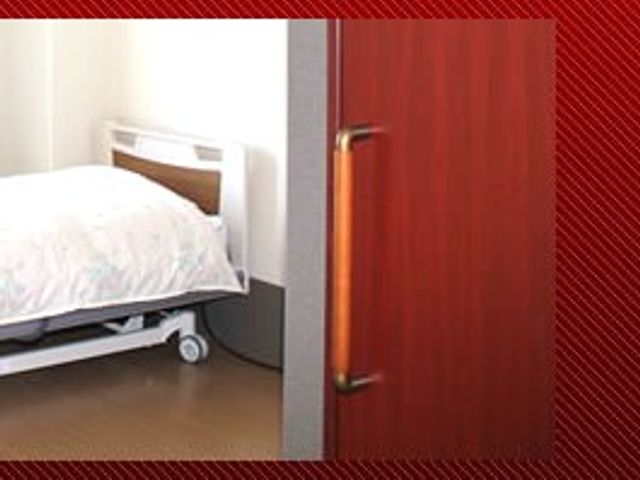 ベッドがある居室 居室 ベッドと木目調のドアが見える落ち着いた個室です。入居者の方が静かに過ごしやすい印象です。