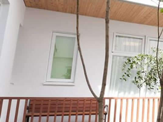 明るい外壁と木製ベンチ