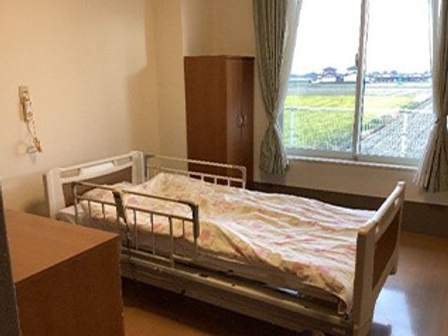 明るい居室のベッド 居室   大きな窓から光が入り、明るく落ち着いた居室です。ベッド周りにゆとりがあり、動きやすさが伝わります。