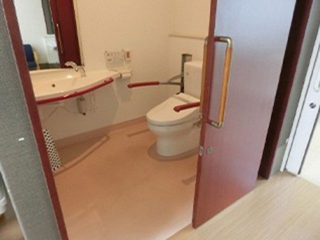 手すり付きのトイレ トイレ   出入口が広く、手すりが設けられた使いやすいトイレです。車椅子での移動にも配慮したつくりに見えます。