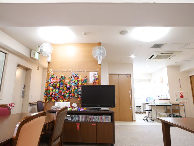明るい多目的室 テレビ台 カラフルな折り鶴が飾られた快適な空間です。共有スペースでの憩いの時間を想像してみてください。
