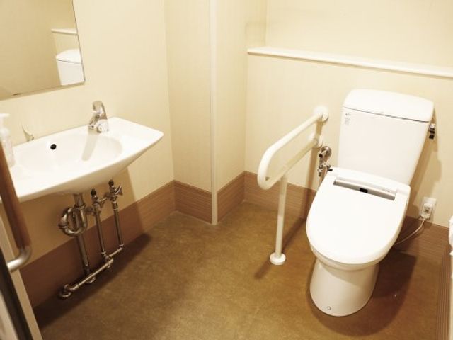 バリアフリートイレ設備 トイレ２ 手すり付きの清潔なトイレで、安全かつ快適な毎日をサポートします。利用者の自立を促す配慮が行き届いています。