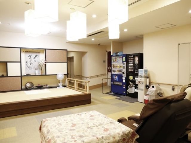 和風な共有スペース 談話コーナー 落ち着いた雰囲気の和室があり、ゆったり過ごせる空間を提供しています。掛け軸や畳が和の趣を感じさせ、日常の憩いの場となっています。