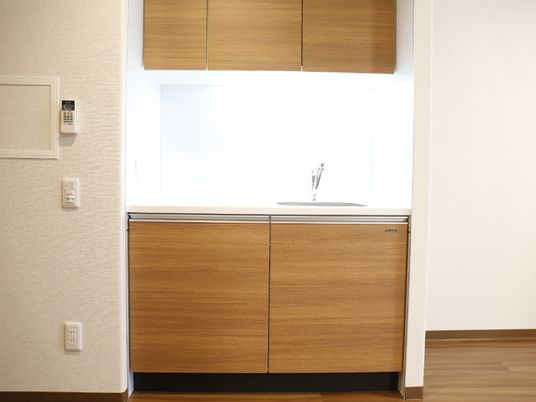 コップや食器の洗い場が居室内にはある。洗った後に食器を乾かせる場所や、保管場所の戸棚も設置されている。