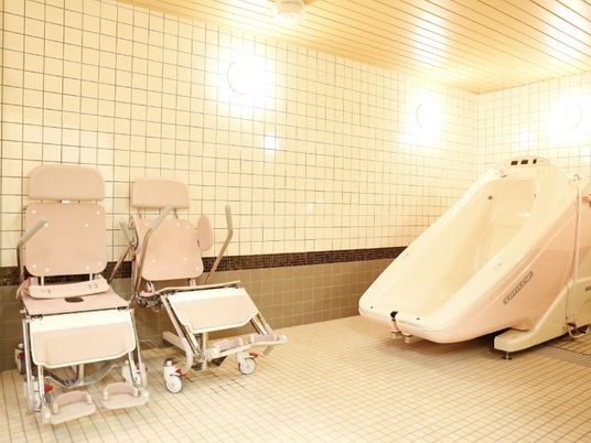 寝たきりのお客様が、お風呂に入ることのできる特別浴室がある。浴室内には、2台のお風呂用の車いすが置かれている。