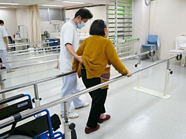歩行訓練をサポート 機能訓練室 ケアスタッフが丁寧にサポートする歩行訓練。安全な環境で、ご利用者の自立を促しています。