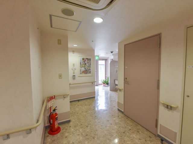 清潔な廊下の風景 廊下 手すりを備えた明るく広々とした廊下は、安全に移動できるように設計されています。壁には絵画が飾られ、温かい雰囲気を演出しております。