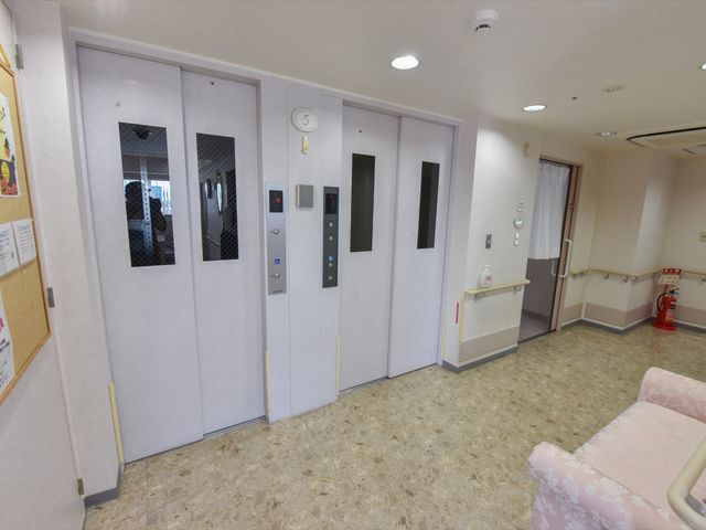 エレベーターホール エレベーター 清潔感のあるエレベーターホールです。広々とした通路は来訪者の動線を考えた設計になっており、スタッフや利用者の方々の快適な移動が可能です。