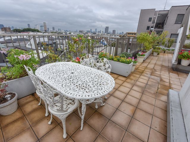 都市の景色を望むテラス バルコニー 開放的な雰囲気の中で、色とりどりの花々に囲まれながら、穏やかなひとときを過ごすことができるテラスです。