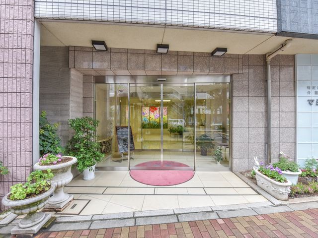 明るいエントランスの様子 入口 開放感のあるエントランスは、訪れる皆様を温かく迎えます。昼光が差し込む空間で、来訪者の方々とのコミュニケーションも楽しめそうです。