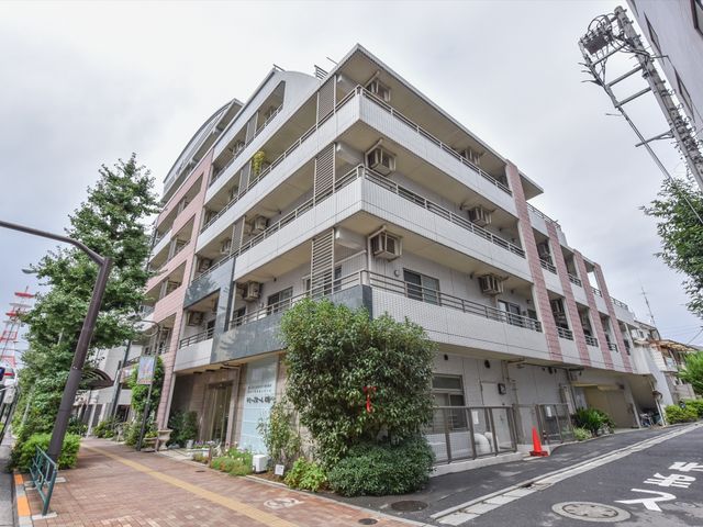 都会の明るい建物外観 外観 清潔感のある建物が並ぶ通りに面しており、周囲に緑が見られる快適な環境です。