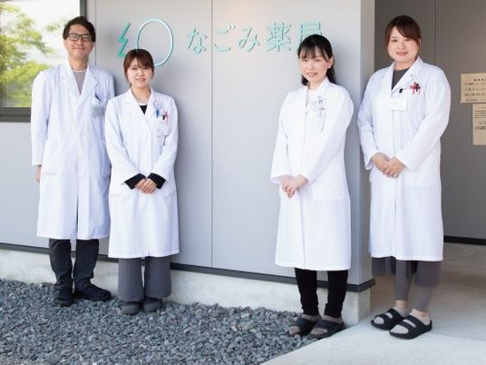 白衣の職員4人と看板の外観  