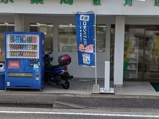 施設前の自販機と旗の外観