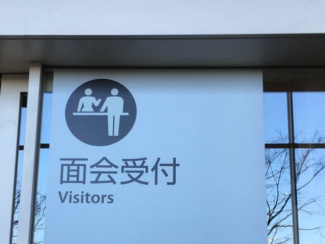 面会受付の案内看板 看板   面会受付を示す大きな案内板です。窓から外の景色が見え、来訪者が分かりやすい場所になっています。