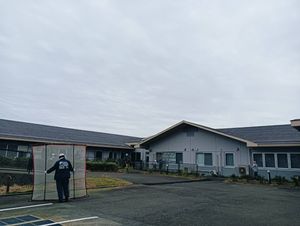 施設の外観と作業中の人  