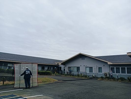 施設の外観と作業中の人  