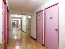 ピンクのドアが特徴の廊下