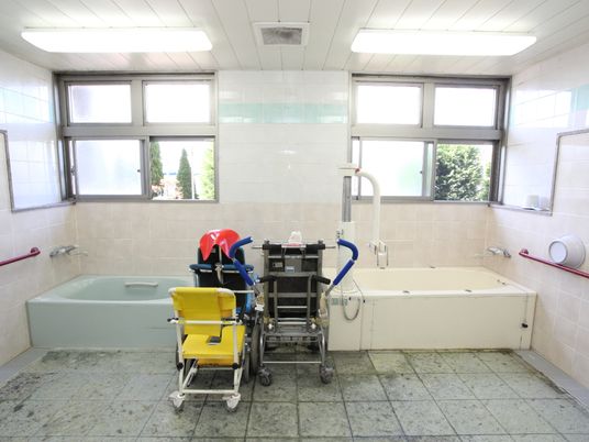 入浴介助のためのリフト付きの装置がある広々としたスペース。大きな窓がいくつもあり、大変明るい空間となっている。"