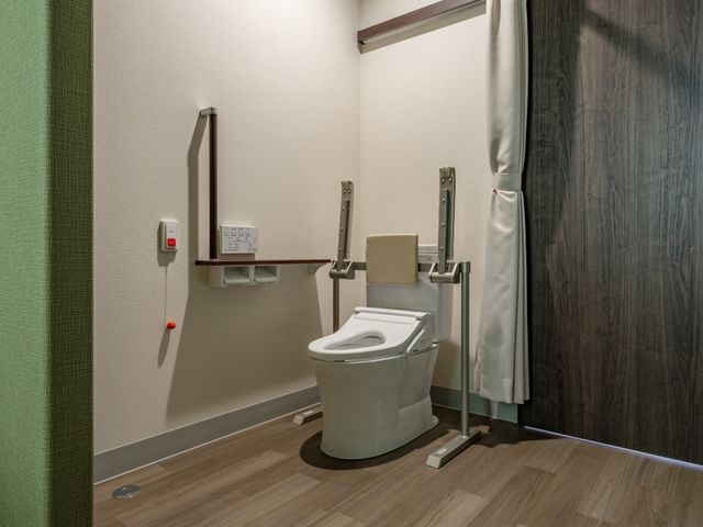 広々としたトイレ トイレ ゆとりのある空間で、手すりが設置された安全なトイレです。介助がしやすく設計されています。