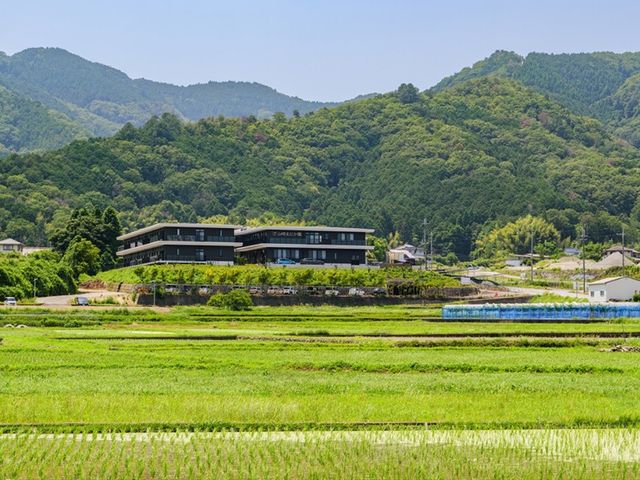 山あいの外観 外観   緑豊かな山並みに囲まれた、落ち着いた雰囲気の建物です。周囲に田畑が広がり、ゆったりとした環境が感じられます。