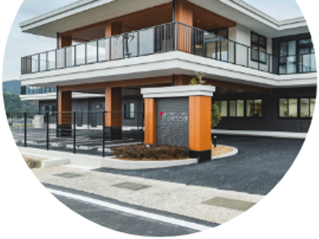 施設の外観 外観   木目調の看板が目を引く、2階建てのすっきりした建物です。駐車スペースも見え、来訪しやすい印象です。