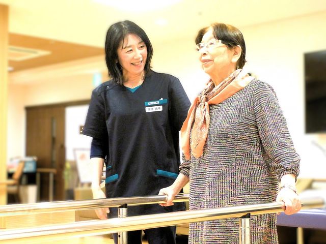 笑顔で歩行を支援する室内 機能訓練室 職員が親身にサポートしながらリハビリを行えます。温かな空間で利用者様の笑顔が見られます。