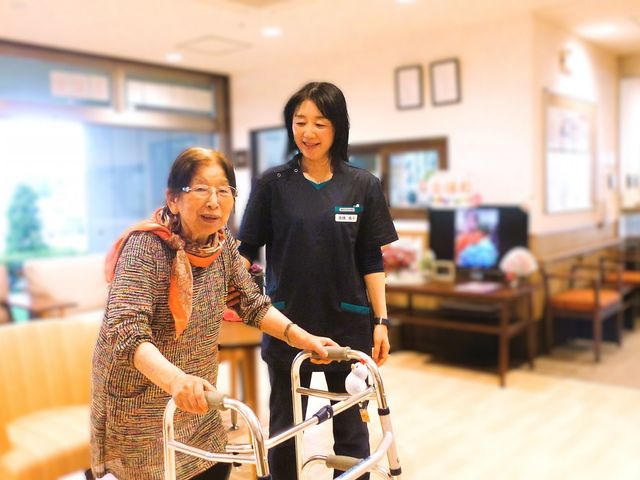 談笑するスタッフと利用者がいる空間 リビング 明るい空間で、スタッフと利用者がリラックスして過ごしています。広々としたスペースが魅力です。