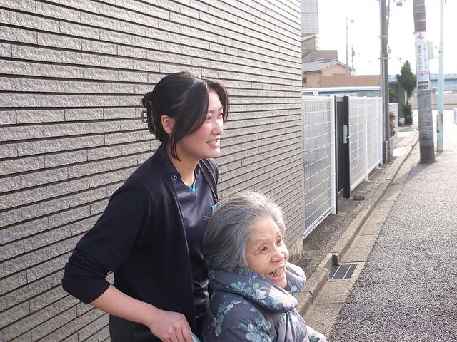 車椅子の介助風景 スタッフイメージ スタッフが温かく笑顔でサポートしており、安心して過ごせる環境です。