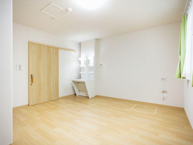 明るい居室の洗面台 居室   木目の床と白い壁で、すっきりとした居室です。洗面台が備わり、窓から光が入りやすい落ち着いた空間です。