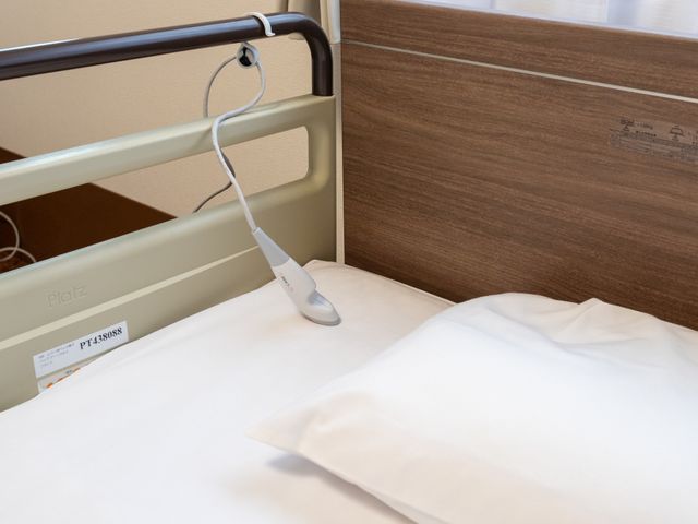 ベッドのある居室 居室 落ち着いた色合いのベッドスペースで、心地よい眠りが期待できます。シンプルなデザインが特徴です。