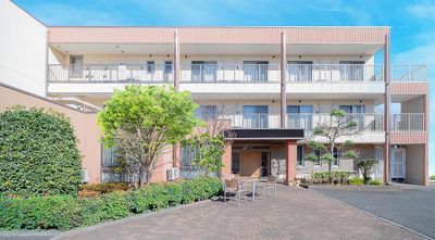 明るい色の外壁の施設外観