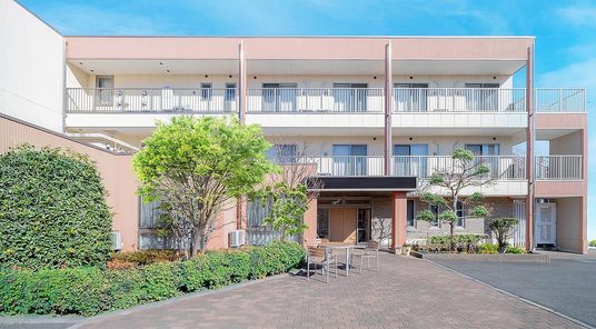 明るい色の外壁の施設外観