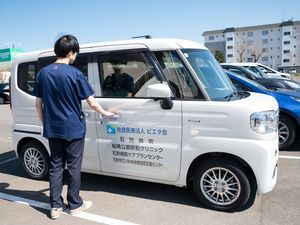 送迎車へ乗車介助する職員  
