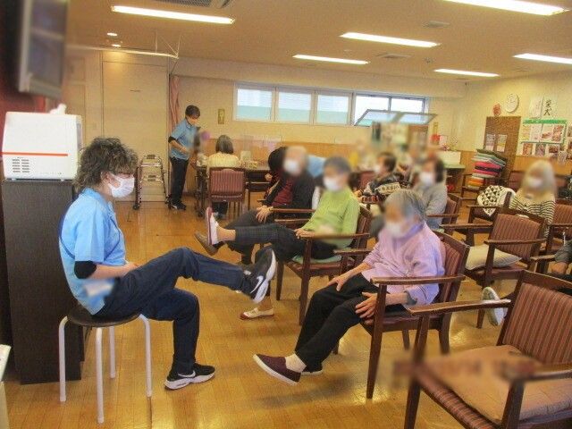 和やかな訓練風景 機能訓練室 明るい室内でスタッフが利用者とリハビリを行っています。和やかな交流の場です。