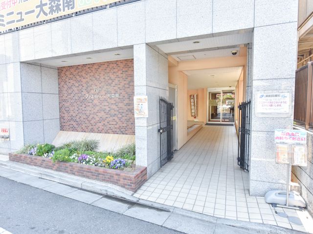 エントランスの開放感ある風景 施設入り口 歓迎感のあふれる開放的なエントランスがお出迎えします。明るい彩りの花が日々の潤いを提供してくれる空間です。
