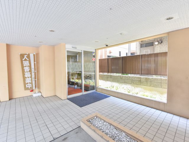 開放感あるエントランスエリア 建物入り口付近 広々としたエントランスは明るく、訪れる方々を温かく迎え入れる空間となっております。ここから新たな職場生活が始まります。