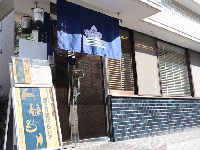 和風の看板と入口 看板 スタイリッシュな和風看板が目を引く施設の外観です。入り口付近は明るく welcoming な印象を与えます。