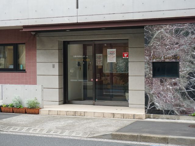 エントランスの外観 玄関 落ち着いた色合いのエントランスは、清潔感があり、歓迎する雰囲気を醸し出しています。職場として、心安らぐ環境が提供されている様子が伺えます。