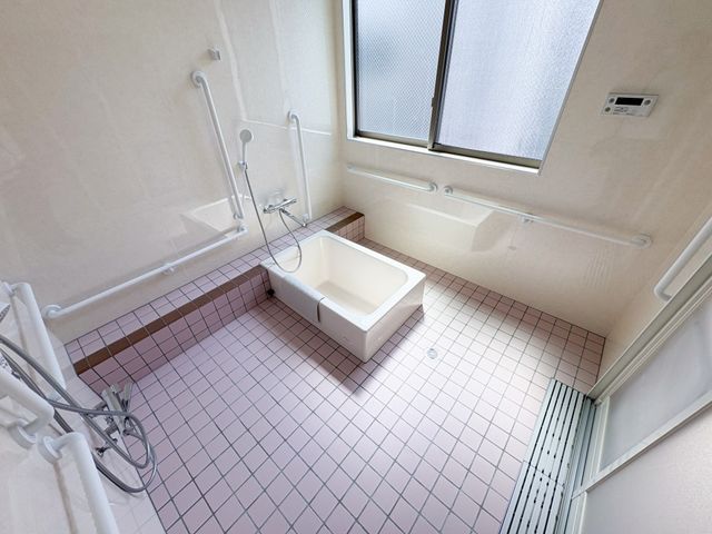 広い浴室 浴室 清潔感あふれる広々とした浴室では、手すりが安心感を提供します。温かな光が差し込む空間です。