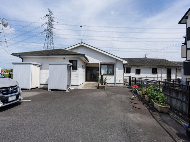 建物の外観 外観 広々とした駐車スペースと清潔感のあるエントランスが印象的で、働く環境としても魅力的です。