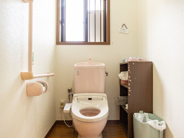 手すり付きのトイレ トイレ 手すりが設置された、ゆったりとしたトイレスペースで、安全に利用できます。照明が明るく、清潔感があります。